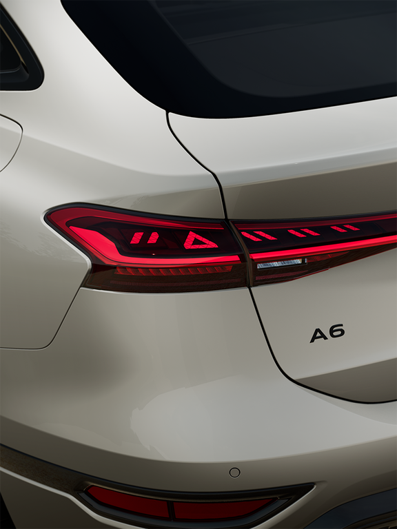 Heckansicht eines weißen Audi A6 Sportback e-tron mit leuchtenden LED-Rückleuchten und gut sichtbarem Kennzeichen.