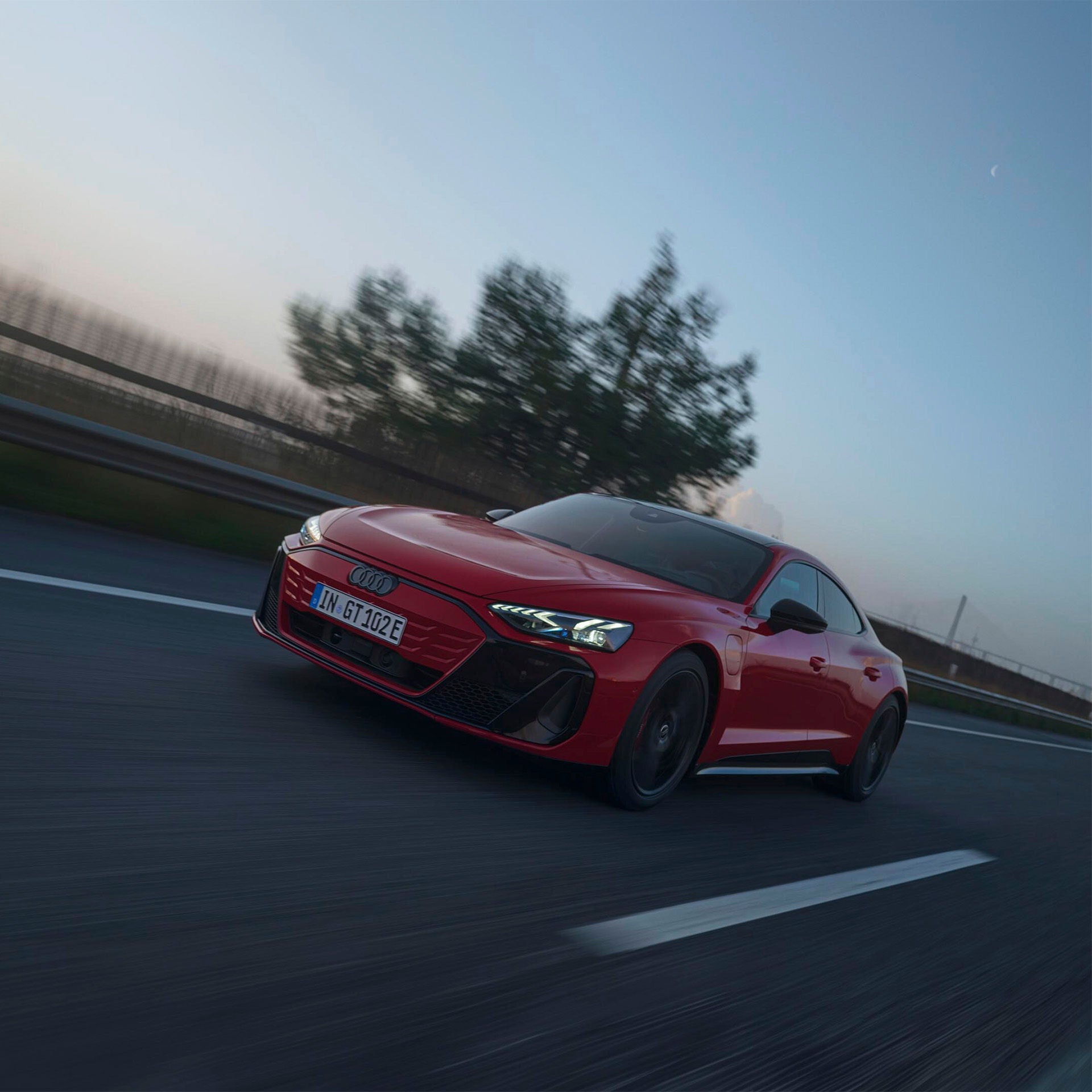 Un Audi RS e-tron GT en una carretera al atardecer. 