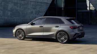 Der S3 Sportback parkt vor einem modernen Gebäude, das Fahrzeug leicht im Schatten.