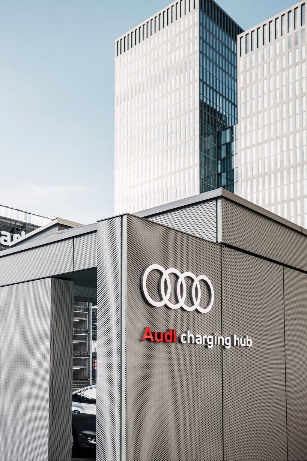 Audi charging hub, high-rise buildings in the background.