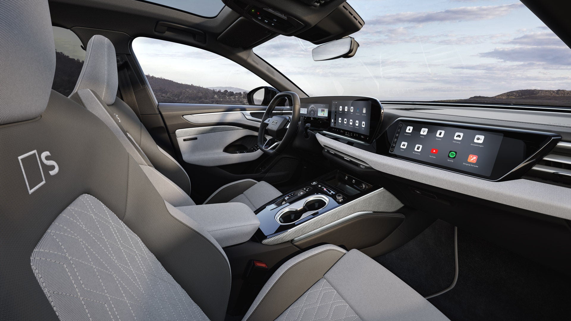 Der Innenraum der A6 Limousine e-hybrid aus der Sicht der Beifahrer B-Säule. Der Fokus liegt auf den Sportsitzen aus dem Stoff hellgrau-neodymgold mit Dekoreinlagen Leinengewebe in hellgrau.