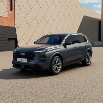 Ein graublauer Audi A3 Sportback von schräg vorne fotografiert vor einer modernen Kulisse.