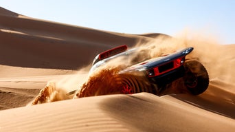 Audi RS Q e-tron roulant par-dessus une dune.