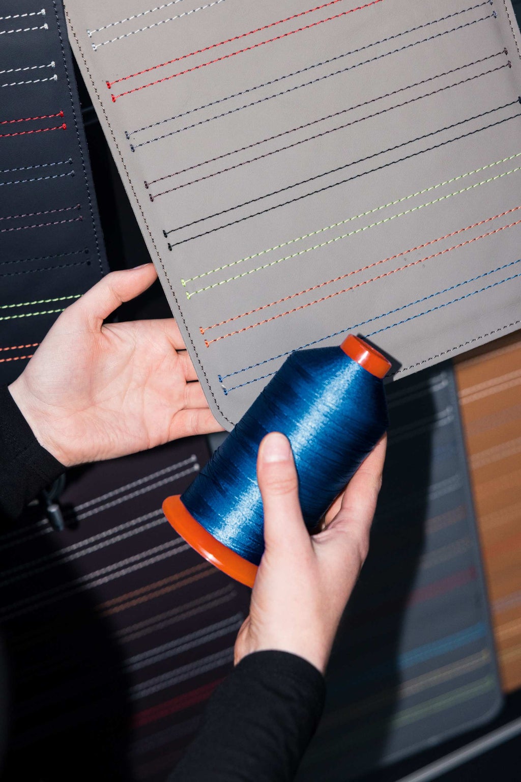 Nahaufnahme eines Farbmusters und einer passenden Garnrolle.