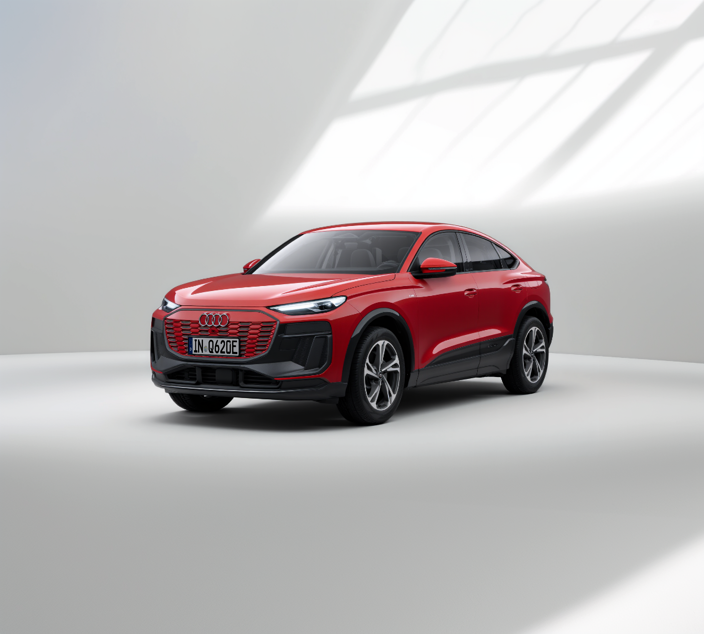 Ein rotes, modernes SUV-Coupé steht in einem hellen Studio mit grauem Boden und weichen Lichteffekten.