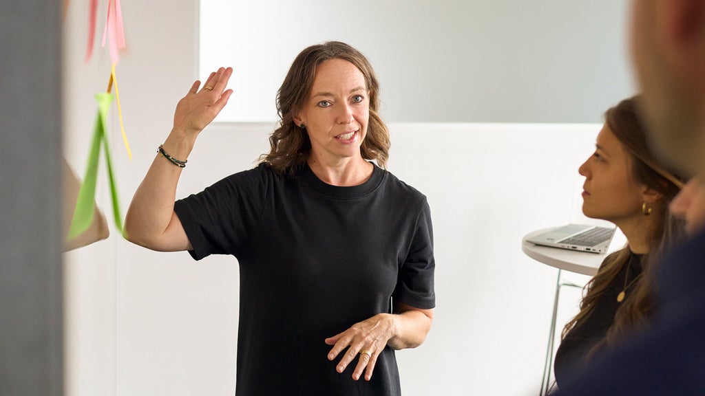 Melanie Limmer ist mit Kollegen im Gespräch und hebt ihre rechte Hand