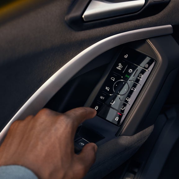 Male hand interacting with a smart door panel featured in selected Audi Vehicles.