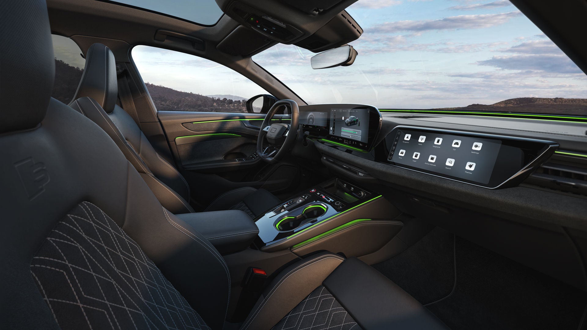 The cockpit of the A6 Saloon e-hybrid from the front passenger's perspective. The focus is on the steering wheel, the panoramic displays, and the green ambient lighting.