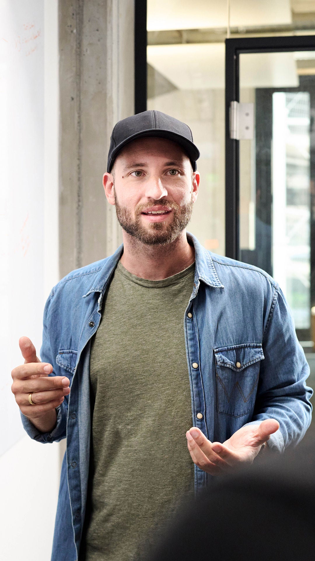 Sebastian Kister unterhält sich mit Kollegen und steht neben einem Sideboard mit Notizen darauf