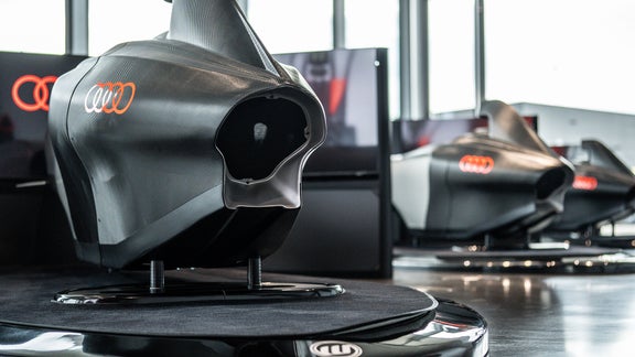 Drei Audi racing Simulatoren: einer groß im Vordergrund, zwei weitere stehen dahinter.