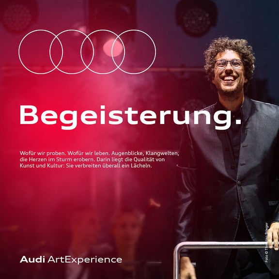Dirigent lächelt auf Bühne im Scheinwerferlicht; Audi ArtExperience und Text „Begeisterung“.