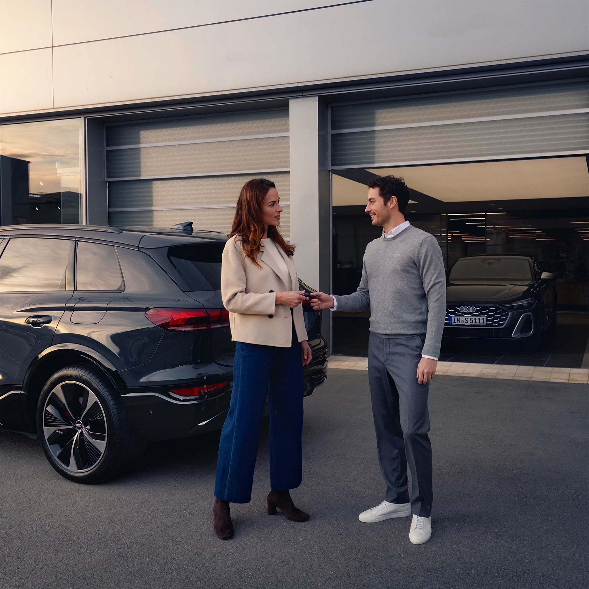 Close up of a woman walking near an Audi car's rear