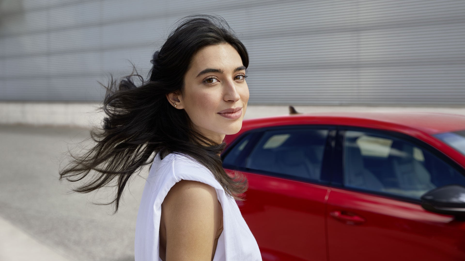 un ragazza di fianco alla propria Audi A3 parcheggiata