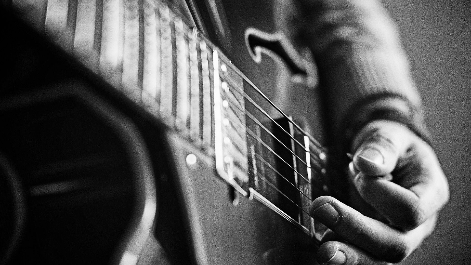 Nahansicht Person nutzt Plektron auf einer Gitarre.