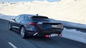 Audi fährt in einer Schneelandschaft mit einer Audi Heckbox.