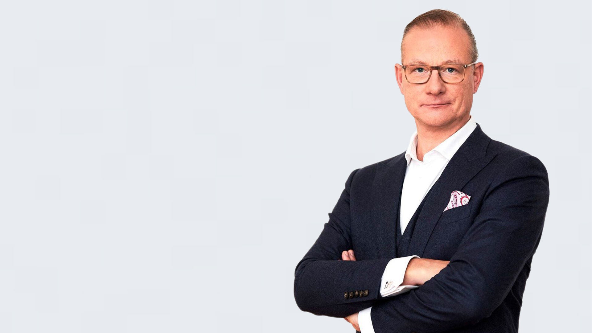 Prof. Dr. Thomas Klindt: Porträt lächelnder älterer Mann mit Brille und Anzug vor grauem Hintergrund.