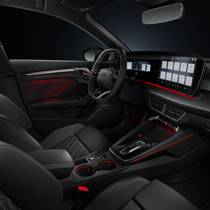 Blick von der Beifahrerseite auf das Cockpit mit Lenkrad, Mittelkonsole, digitale Displays und das Ambiente-Licht.
