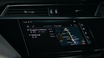 The digital display inside an Audi electric vehicle displaying a driving route on a map of the UK