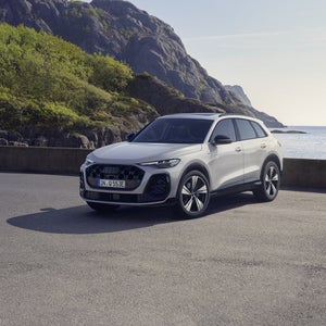 Den grå Edition One-versionen av Q5 SUV e-hybrid står parkerad på en parkeringsplats vid kusten.