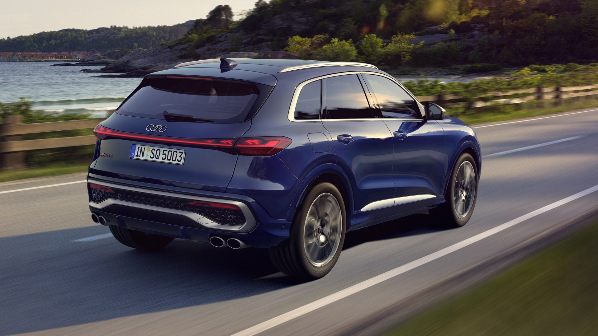 Der SQ5 SUV in dunkelblau, welcher auf einer Straße entlang der Küste fährt.&nbsp;