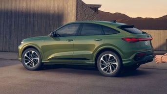 Grüner Q5 Sportback steht vor einem modernem Gebäude, im Hintergrund sind Berge zu sehen.