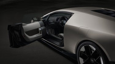 Zijaanzicht van de Audi Nuvolari van achteren schuin, met geopend bestuurdersportier.