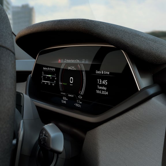 Gros plan sur le cockpit numérique d’une Audi S e-tron GT, avec compteur de vitesse, indicateur d’état de la batterie et affichage de la date et de l’heure. L’écran indique une autonomie restante de 425 km et diffuse le morceau « Purple Rain ».