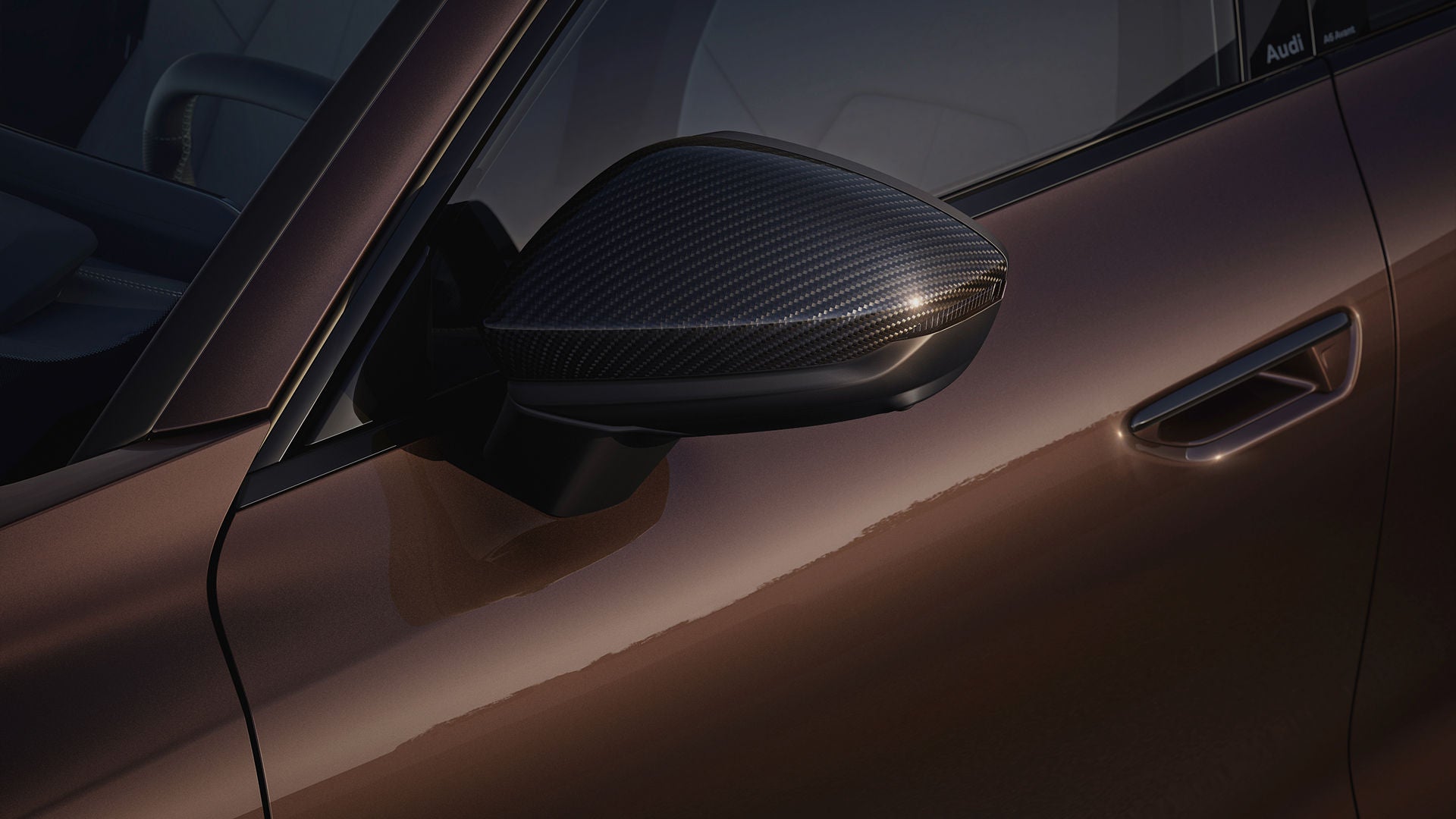 Close up of a brown Audi's door with rear view mirror and door handle in sight