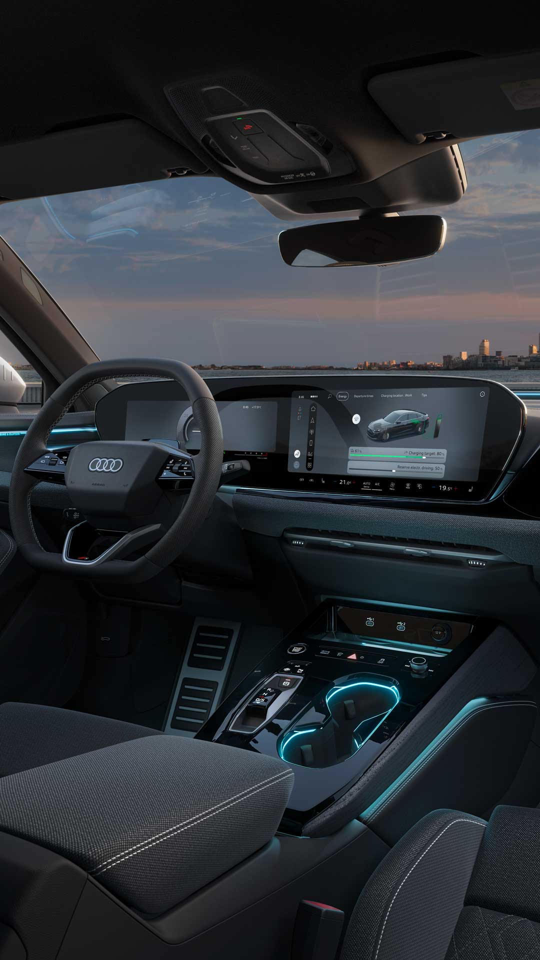 Utsikt från baksätet in i förarhytten på A5 Sedan e-hybrid. Bland annat syns MMI touch-displayerna, omgivningsbelysningen och interaktionsbelysningen. I bakgrunden syns en stadssilhuett.