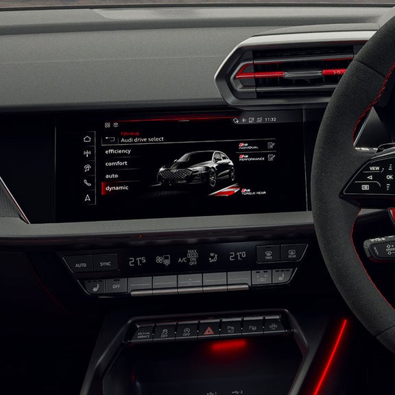 The dashboard display in a RS 3 Sportback car showing Audi drive select options: efficiency, comfort, auto, and dynamic mode. Sleek design with digital controls.