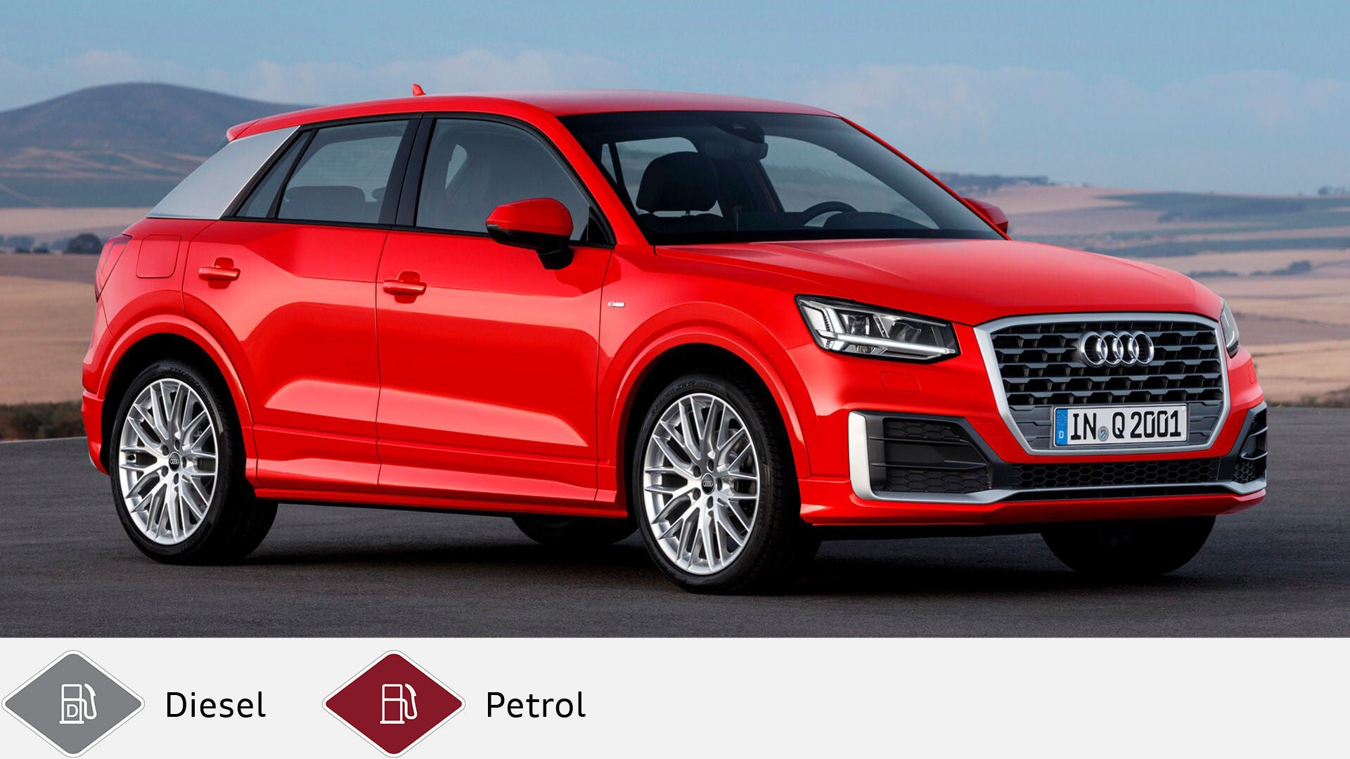Red Audi Q2 standing on a road in front of a hilly landscape in daylight. Below gray diesel symbol and red gasoline symbol.