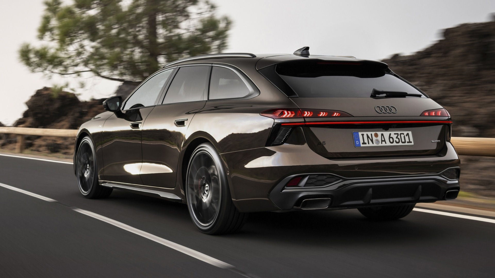 Heckansicht eines Audi A6 Avant, der eine Straße entlang fährt.