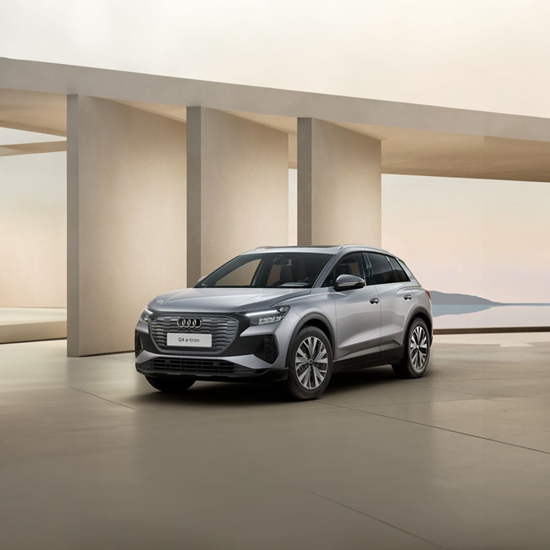 A purple Audi Q4 e-tron stands in a room with white walls and light shining through the ceiling. Beams form shadows on the wall. 