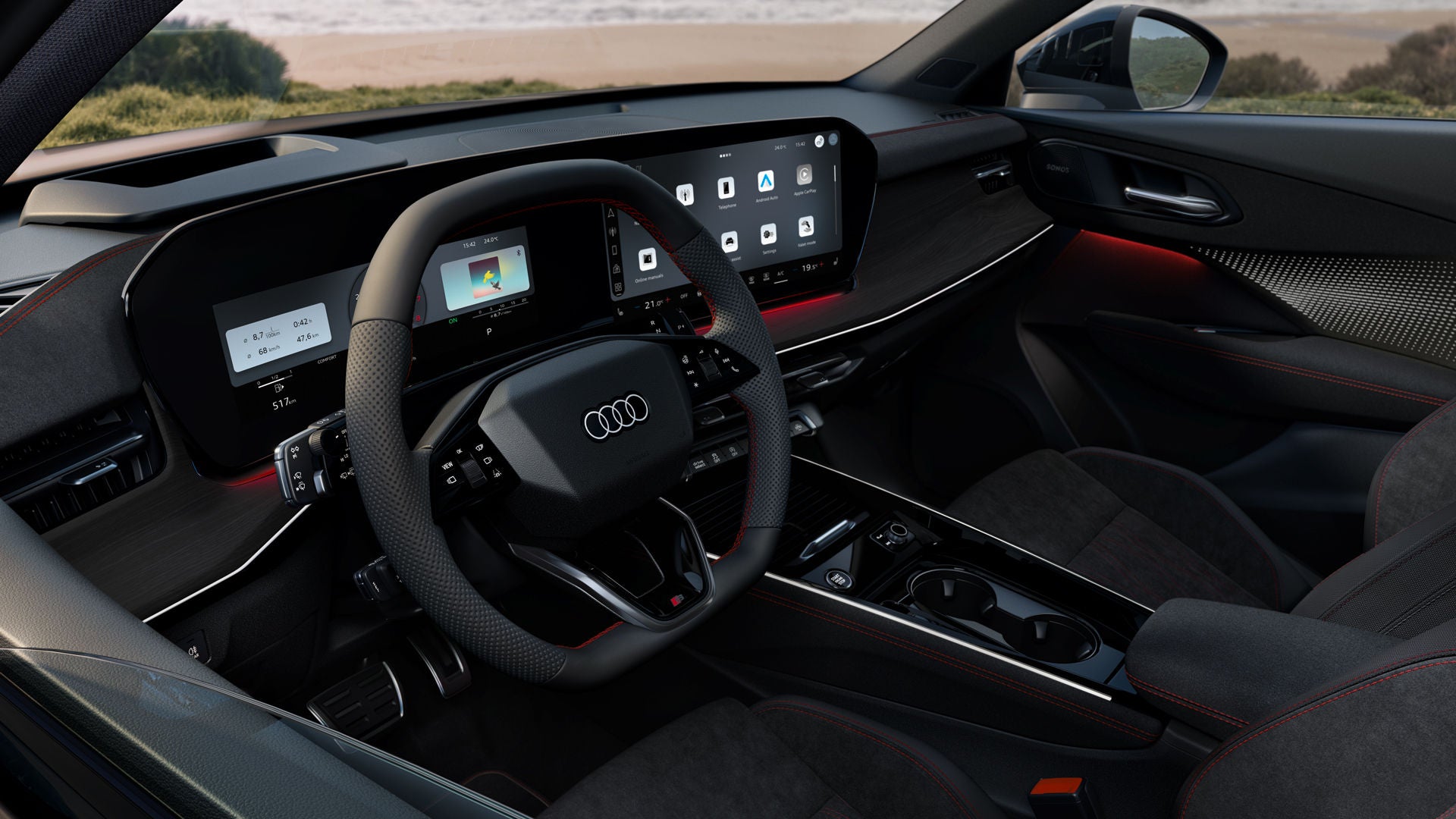 Vista posteriore del cockpit della Audi Q3 Sportback con volante, display panoramico e pacchetto di illuminazione ambientale rossa. Il mare è visibile attraverso il parabrezza.