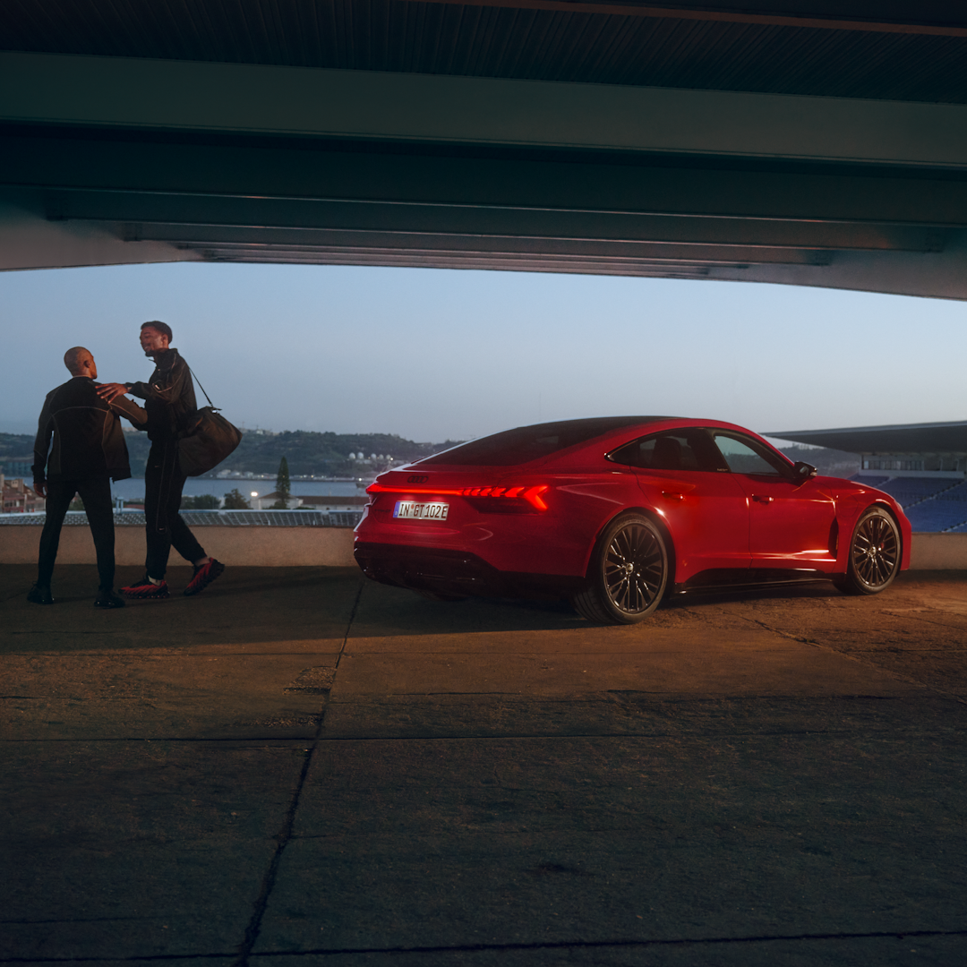 To personer ved siden af en rød e-tron GT  