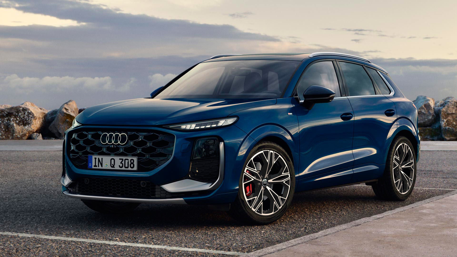 El Q3 SUV en color Ascariblau metalizado, visto desde el lateral, aparcado en una carretera costera.