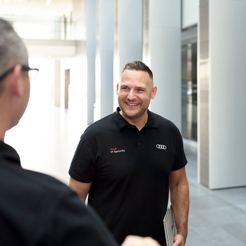 Andreas Walter lächelt einen Kollegen an