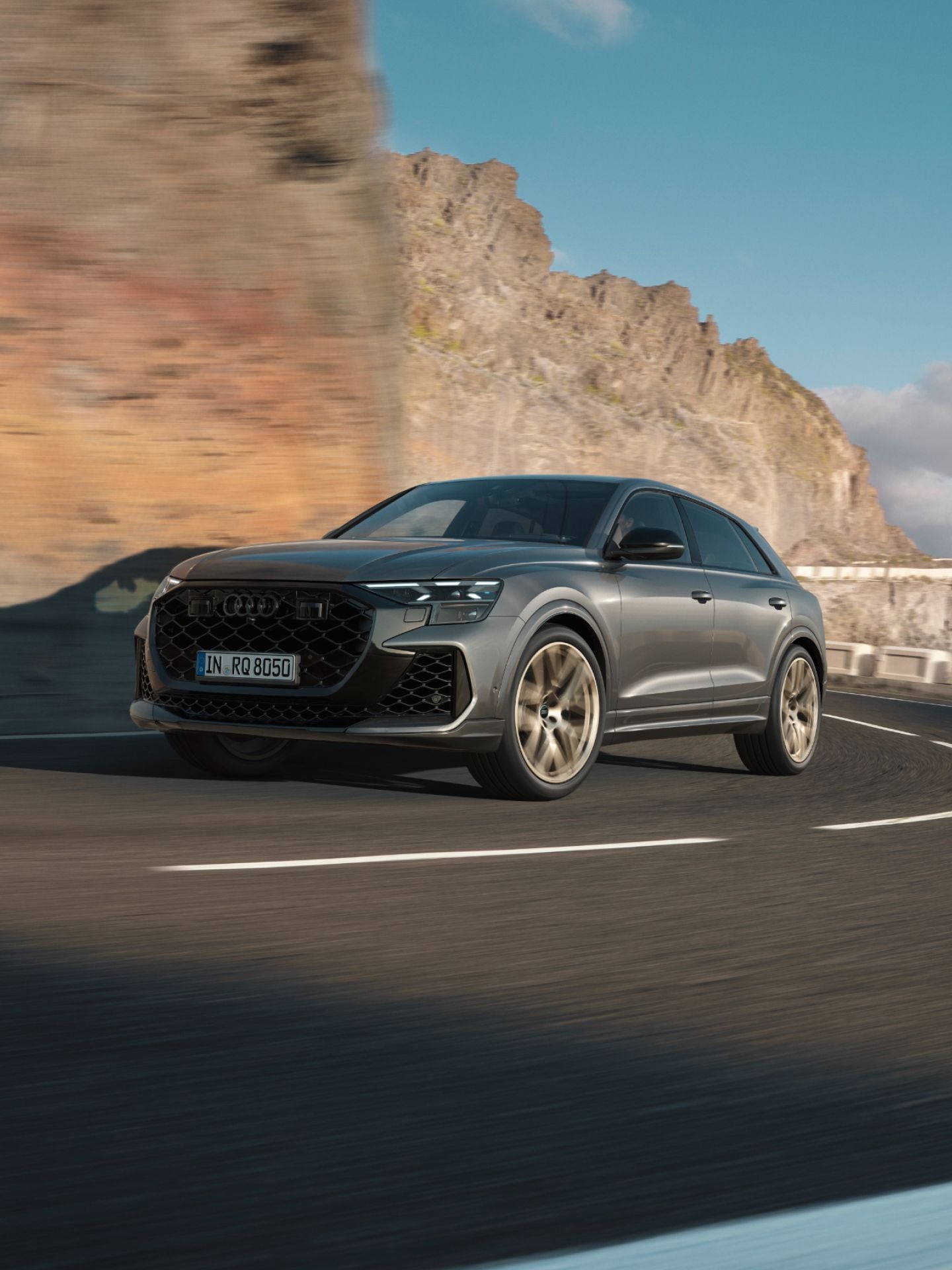 Audi RS Q8 driving up a mountainside with a blurred background.