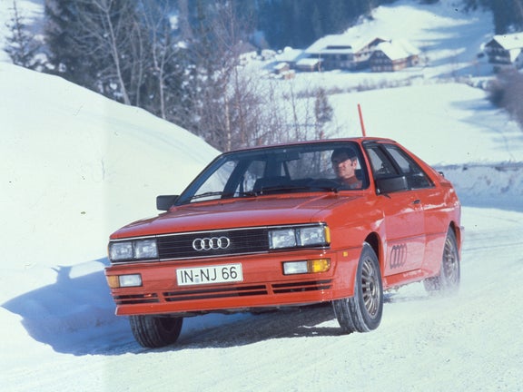 Frontal shot of a red Audi quattro in snow-covered mountains