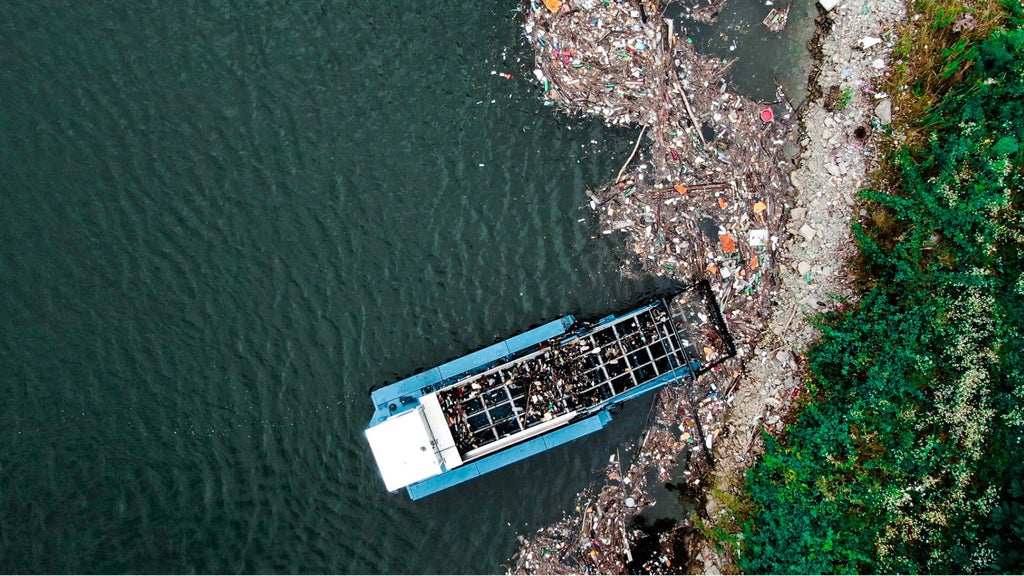 A bird's eye view of a rubbish collection boat on a river
