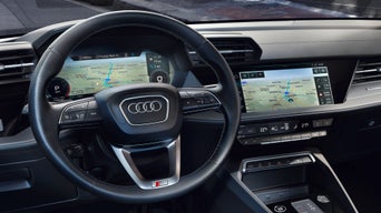 3D-Stadtkarte auf dem digitalen Tacho hinter dem Audi-Lenkrad mit eingeblendeter Navigation.
