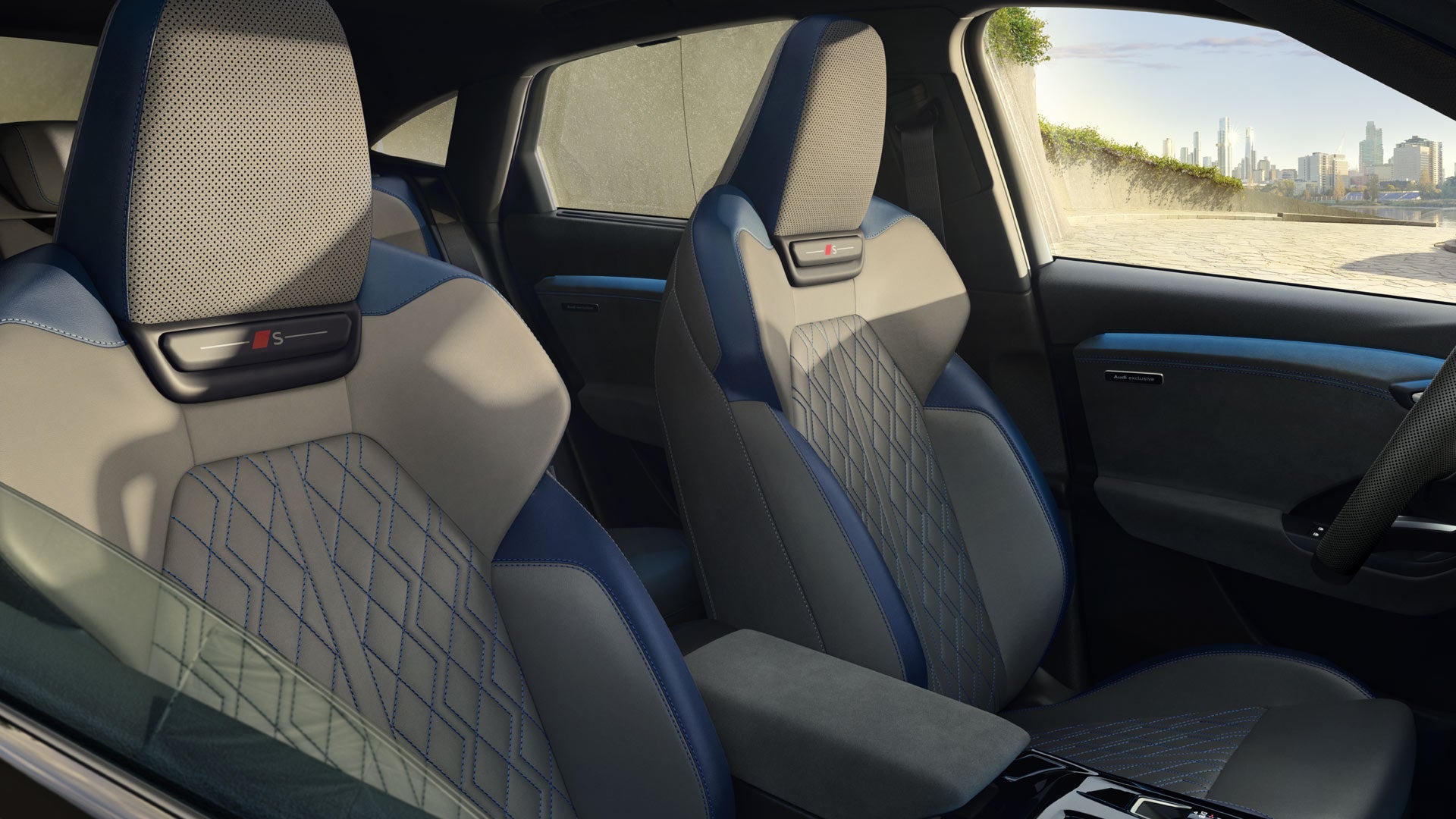 The front two seats of the Q6 Sportback e-tron from the perspective of the half-open passenger window. The interior features the Jet Grey/Ocean Blue design package.