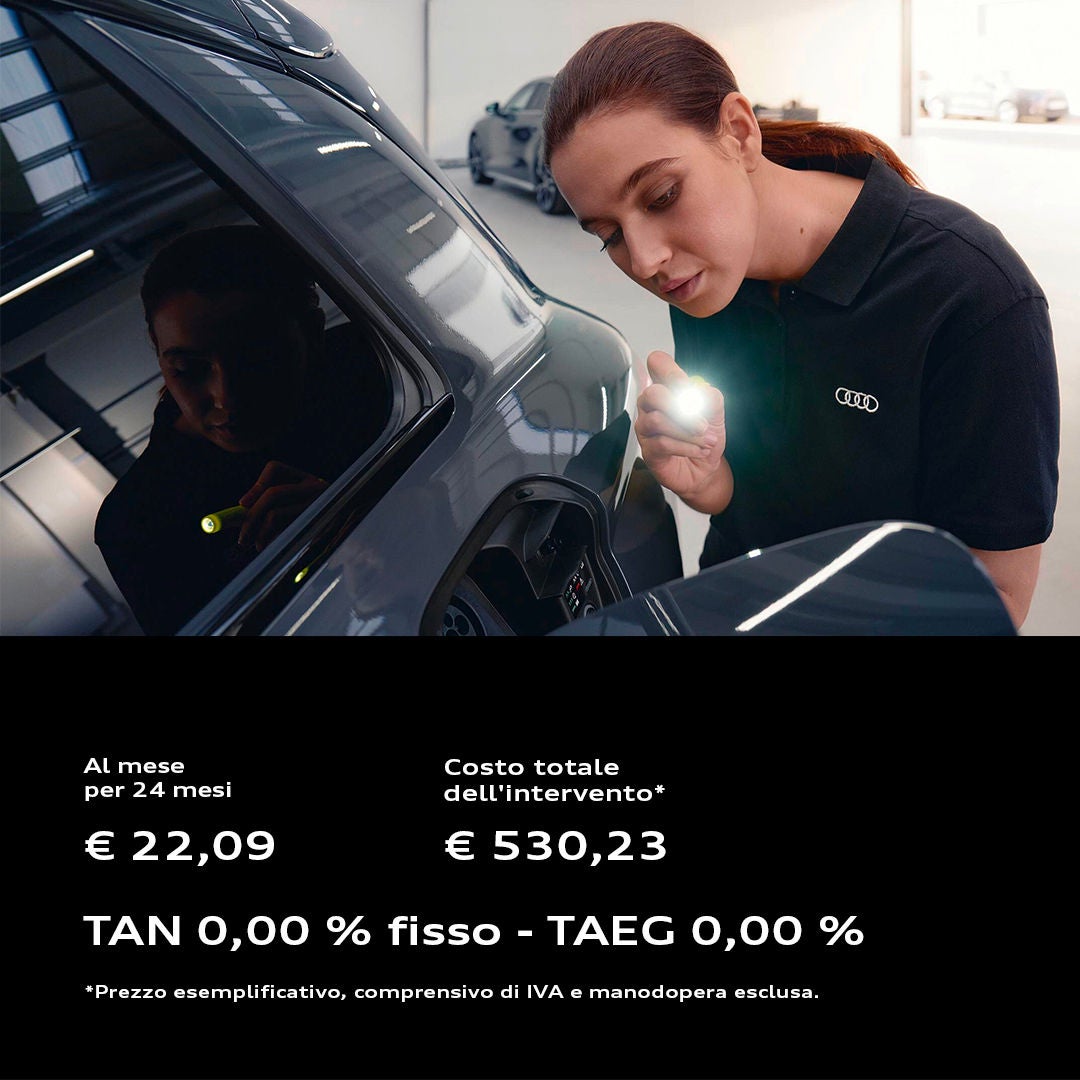 Un'addetta all'officina sta installando un disco freno nuovo su un'auto Audi.
