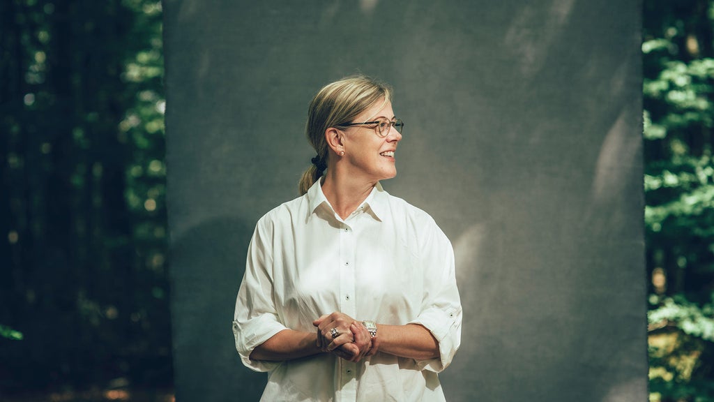 Ulrika Hasselgren blickar ut åt sidan, hon står med händerna knutna med ett leende på läpparna