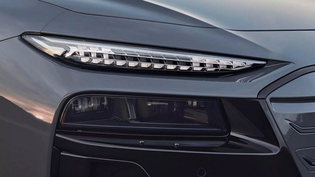 Close-up of a sleek car's headlight, showcasing modern design with angular LED elements and a dark housing for a futuristic aesthetic.