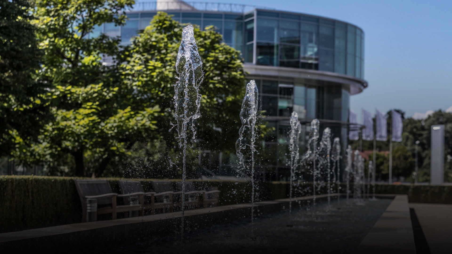 Gebäude des Audi Forum Ingolstadt, davor kleine Wasserfontänen.