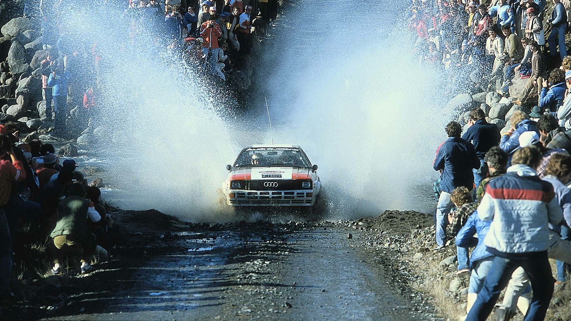 Das Foto zeigt ein Audi quattro-Rallyeauto bei einer Wasserdurchfahrt in Neuseeland 1982.