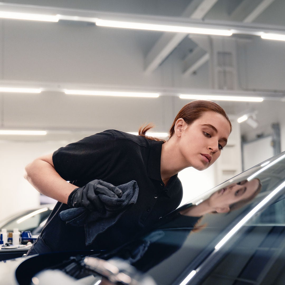 mujer revisando parabrisas de audi