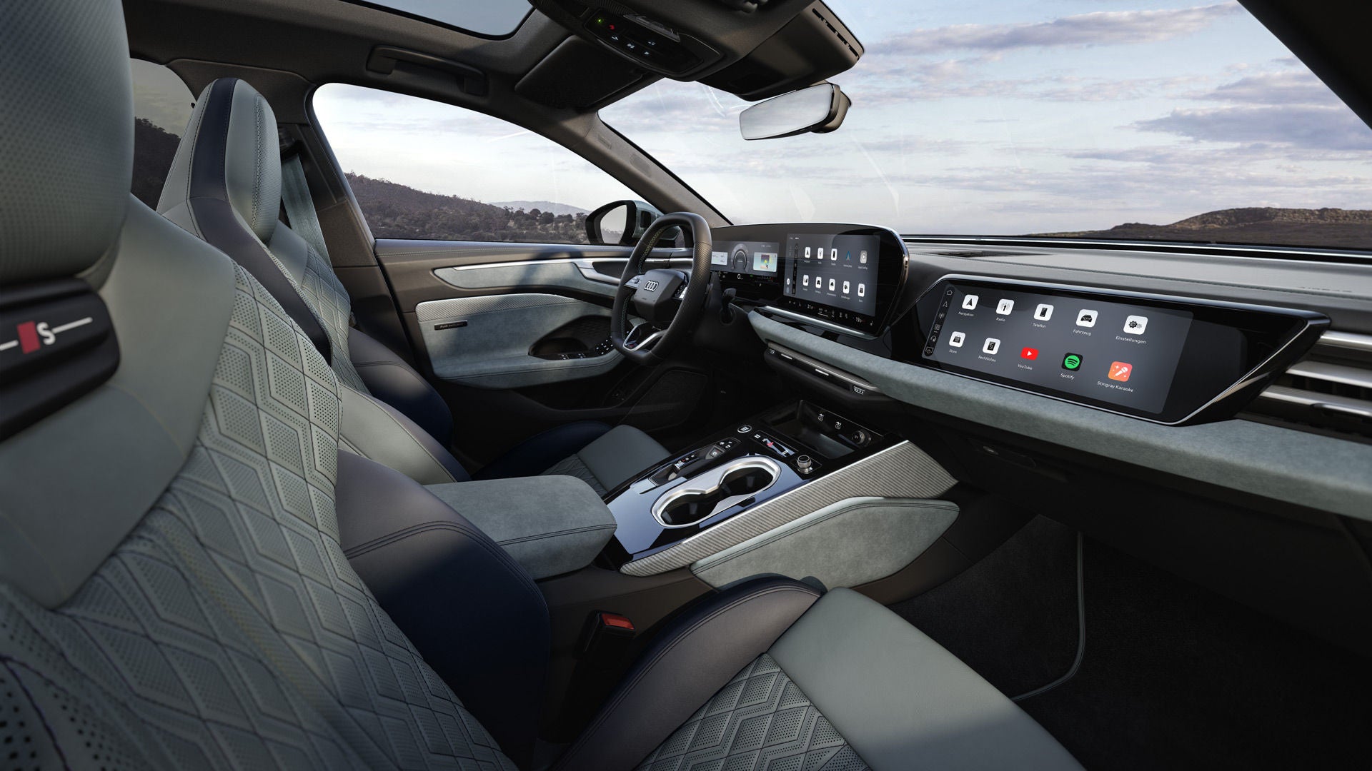 Blick durch das Beifahrerfenster in das Cockpit des A6 Avant e-hybrid. Das Interieur hat mintgraue Bezüge.