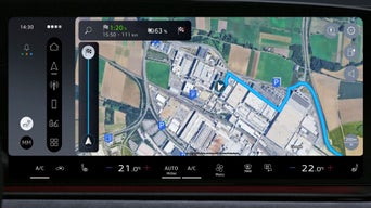 Navigationsansicht auf dem digitalen Tacho zeigt kurvige Straßen und Flusslauf in hoher Auflösung.